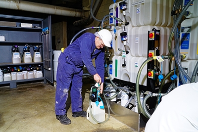 Lube technician dispensing oil into an isolink container