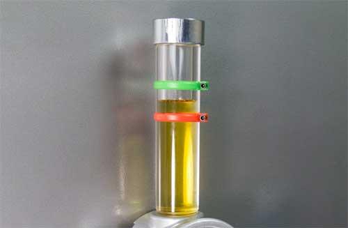 A columnar level gauge showing the oil level in a sump.