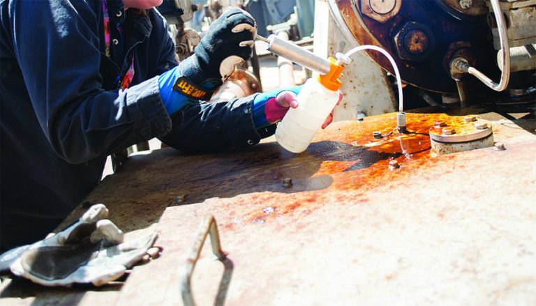 A lubrication technician, or “lube tech” takes an oil sample using a sealed bottle to keep out contaminants.
