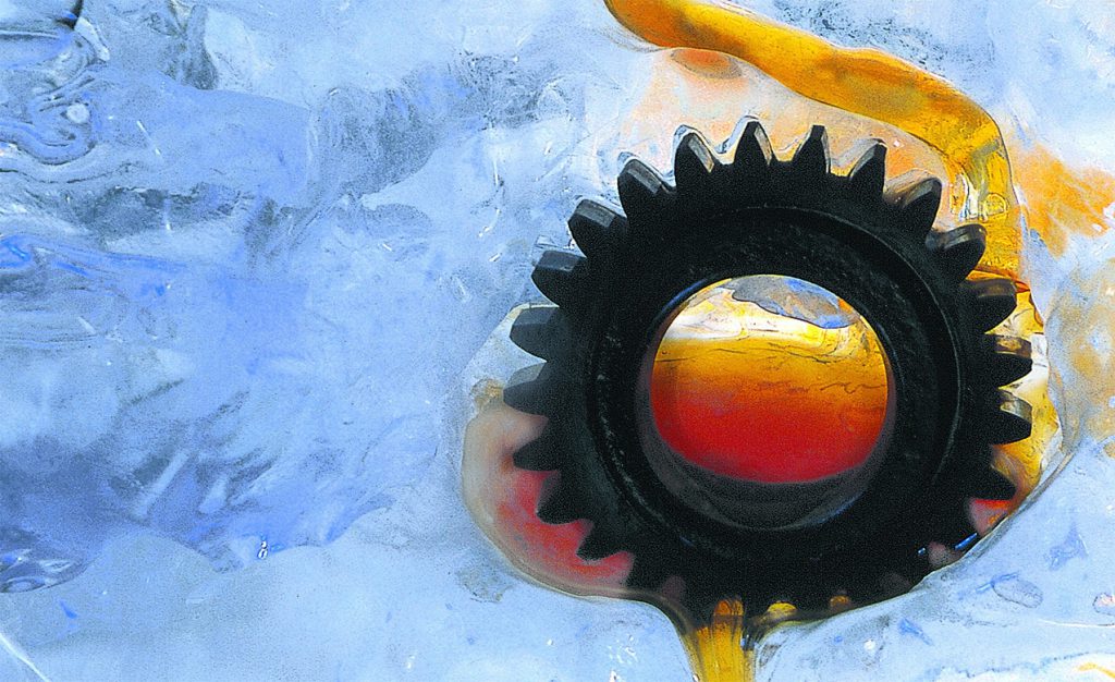 Gear from a gearbox shown resting in ice with gear oil flowing over it