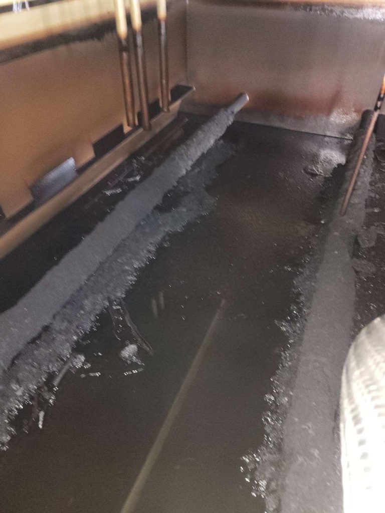 Inside of a dirty lube oil reservoir prior to an oil flush and confined space reservoir cleaning